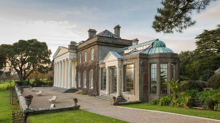 The white pyramid entrance at the front of Trelissick, in the autumn, with the orangery at the right of the picture